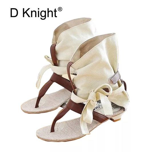 Beige canvas espadrille sandals with brown straps and bow detail.