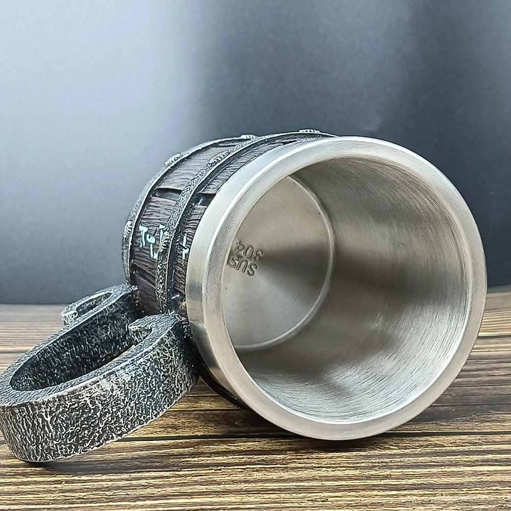 Camera lens-shaped stainless steel mug on wooden surface with cap off.