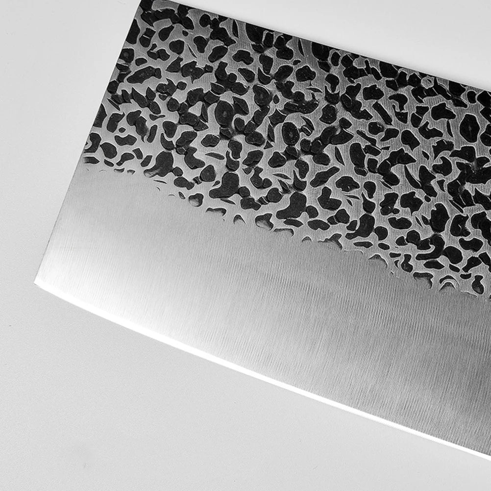 Close-up of a knife with a patterned, etched steel blade.