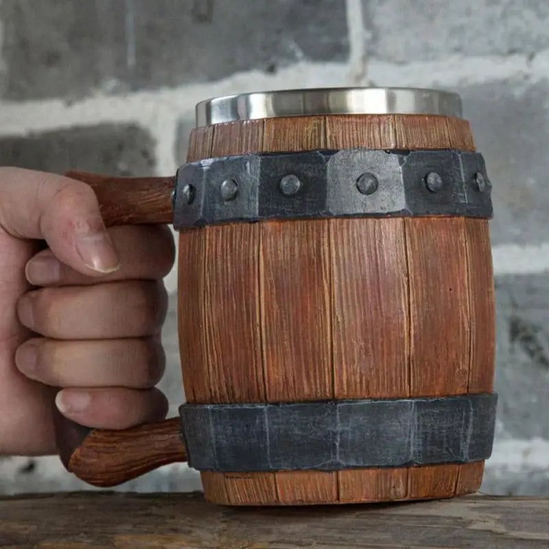 Hand holding a wooden mug designed to look like a barrel.