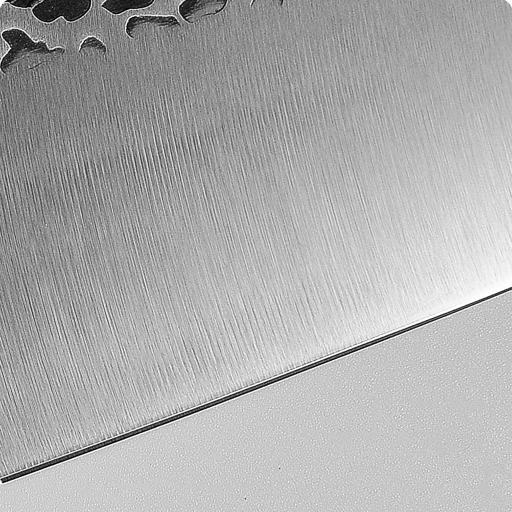 A close-up of a brushed metal surface with cut-out shapes.