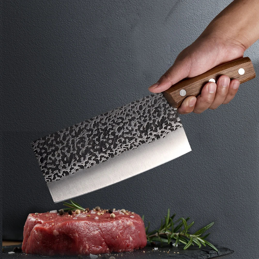 Hand holding patterned knife above raw steak with herbs.